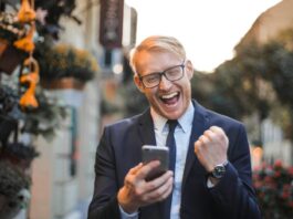 man med telefon som hejar
