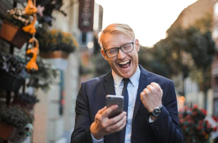 man med telefon som hejar