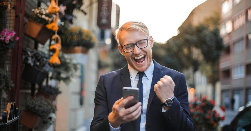 man med telefon som hejar